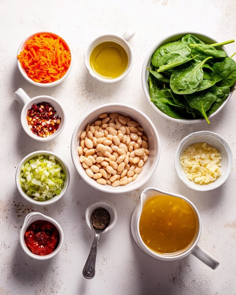 The image shows multiple small white bowls and one white pitcher arranged on a white marbled surface. The center bowl contains a large amount of white beans that have a smooth texture and oval shape. Around it, bowls hold finely chopped orange carrots, light green celery, and chopped red shallots. There is a small white bowl with a mixture of spices that include red and green tones, and a tiny white bowl with minced garlic that looks creamy and soft. A glass white pitcher is filled with a golden broth and sits on the right side. A larger white bowl on the upper right side is filled with fresh bright green spinach leaves, which have a slightly wrinkled texture. Near the pitcher, a small white bowl holds ground black pepper with a little spoon. Also on the left is a small white jug filled with light golden olive oil, and a tiny clear bowl with deep red chili paste. The setup is clean and organized, with all bowls clearly showing the fresh ingredients. Photo taken with an iphone --ar 4:5 --v 7