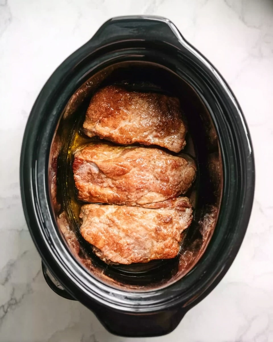 The image shows a black slow cooker on a white marbled surface. Inside the slow cooker, there are three large cooked pieces of light brown meat stacked neatly side by side. The meat has a slightly textured surface with a cooked, warm look but no sauce or garnish is visible. The slow cooker handle is visible at the top, and the pot itself has a smooth, shiny black finish. Photo taken with an iphone --ar 4:5 --v 7
